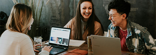 adults collaborating at a table with computers